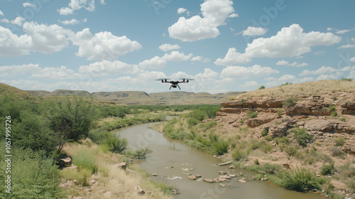 Drone flying over a river winding through a dry, rocky landscape.