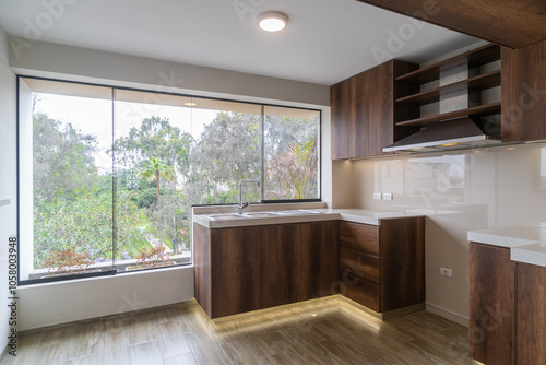 cocina amoblada con alancena ,estufa, muebles altos y bajos , acabados de madera e iluminada