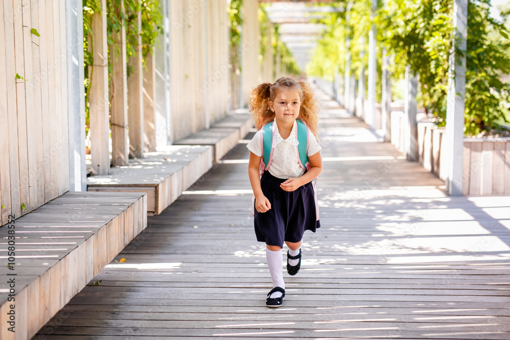 Happy little schoolgirl with school bag in school garden. Back to school outdoor Happy little schoolgirl with school bag in school garden. Back to school outdoor