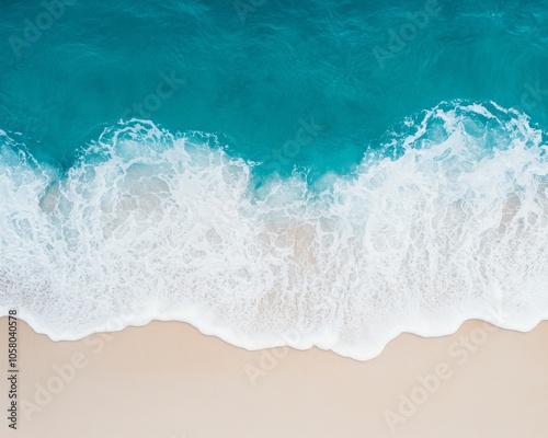 Aerial view of ocean waves meeting sandy beach.