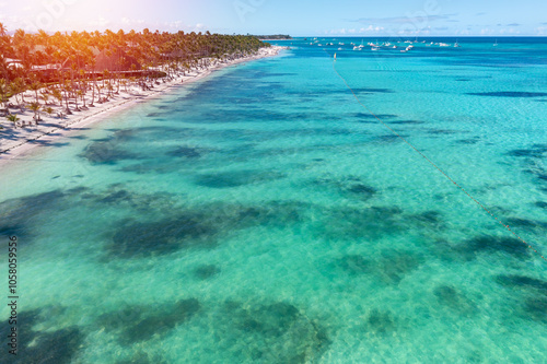 Sunset or sunrise on tropical beach with resorts, palm trees and caribbean sea. Dominican Republic. Aerial view photo