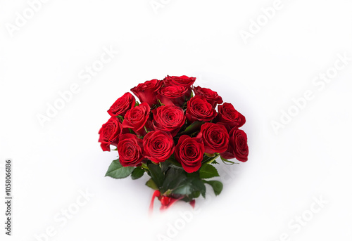 A bouquet of deep red roses, tied with a red ribbon, against a white background.