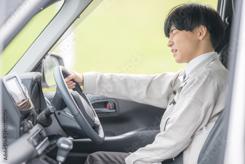 悲しそうな運転する作業服男性