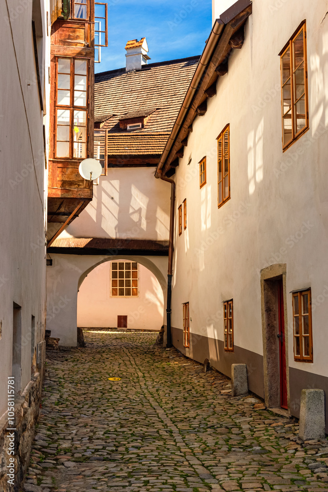 Summer cityscape - view of the lane with archway in the historical center of Cesky Krumlov, Czech Republic