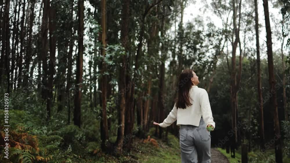 A beautiful smiling girl runs, spins and jumps in the rain in a eucalyptus forest, nature and ecology, climate, happiness, emotions, expression, dynamics, youth, travel, sincerity, carefree, real A beautiful smiling girl runs, spins and jumps in the rain in a eucalyptus forest, nature and ecology, climate, happiness, emotions, expression, dynamics, youth, travel, sincerity, carefree, real