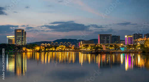 Serene Cityscape at Dusk Reflecting on a Calm Water Surface