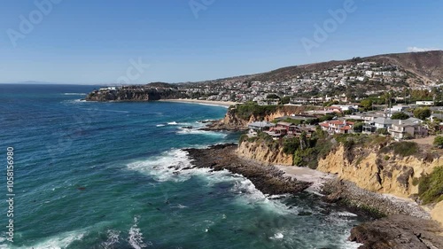 Flying along the Laguna Beach coastline with Emerald Bay in the background in Orange County, Southern California. 