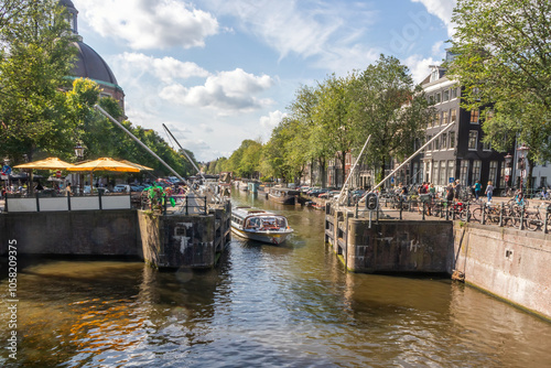 Tourist boat approaching lock gates on the Singel, Amsterdam, Netherlands