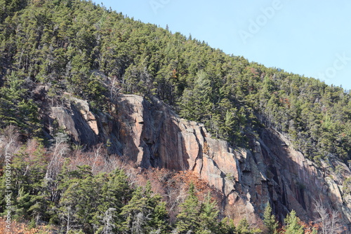 A cliff in autumn and in a park of Charlevoix. Escalation and rock in a forest. Outdoor activities, hilking and exploration in national park. Canada trails and park in Quebec. October landscape.  photo