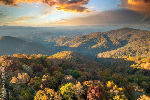 Wooded Appalachian mountains in North Carolina at sunset with yellow forest trees at fall season. Beauty of autumnal nature