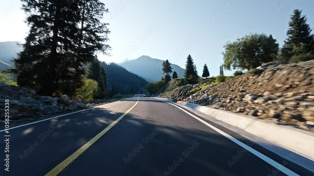 Driving car on a mountain road. Ahead is a green forest and mountain nature landscape in summer.