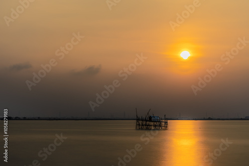 Sunset Splendor With A Beautiful Evening by the Sea. Lone Fisherman’s Bagan Floating on Expansive Blue Waters.