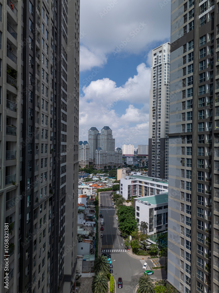 View between modern luxury high-rise buildings in dramatic light with views over road and urban area on sunny day. High angle viiew. View between modern luxury high-rise buildings in dramatic light with views over road and urban area on sunny day. High angle viiew.