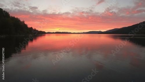 Vivid orange and pink hues reflecting on calm waters of Hintersee lake during autumn sunset, nature, reflection, sky