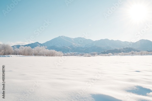 Serene winter landscape with snowy mountains under a bright sunlit sky