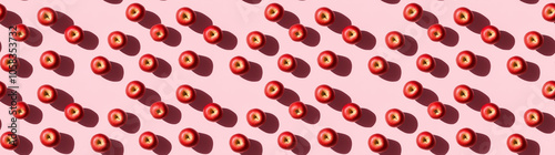 A seamless pattern of apples, each with its shadow, scattered across the canvas in an elegant display, with soft shadows on a pink color background