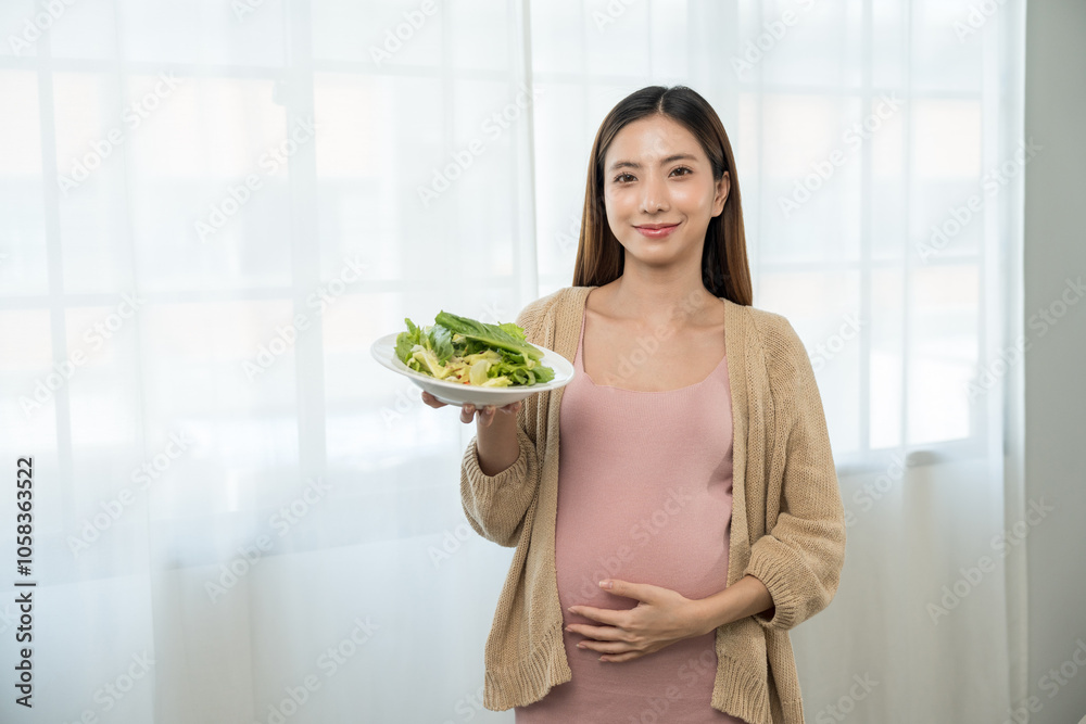 Happy pregnant woman eating vegetable salad and smiling to camera, concept of healthy mother taking health care and nourish her fetal and waiting her childbirth. Happy pregnant woman eating vegetable salad and smiling to camera, concept of healthy mother taking health care and nourish her fetal and waiting her childbirth.