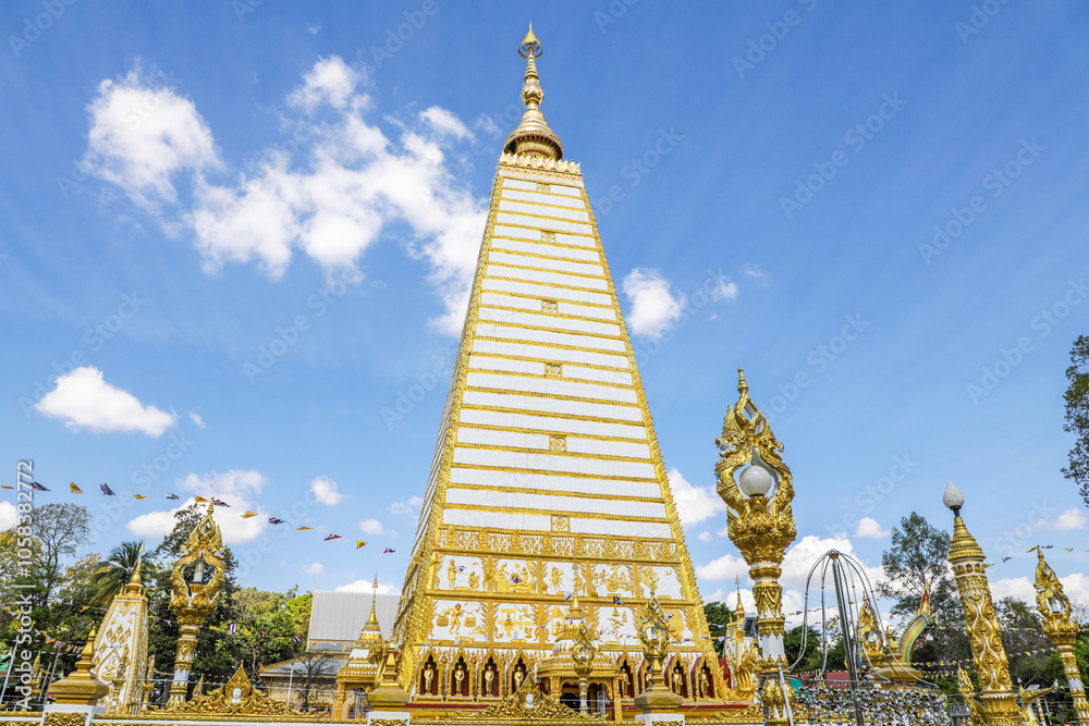 Naklejka premium Wat Phra That Nong Bua, Ubon Ratchathani, inside there is the Phra That Sri Maha Bodhi Chedi, a replica of the Chedi in Bodh Gaya, India, stucco sculptures, candles, and two large Naga statues.