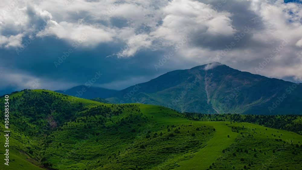 White clouds flying over green foothills at sunny summer day in Kyrgyzstan drone point of view time lapse. White clouds flying over green foothills at sunny summer day in Kyrgyzstan drone point of view time lapse.