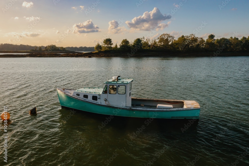 Naklejka premium Fishing boat moored in the harbour at sunset. Orr's Island, Harpswell, Maine, United States.