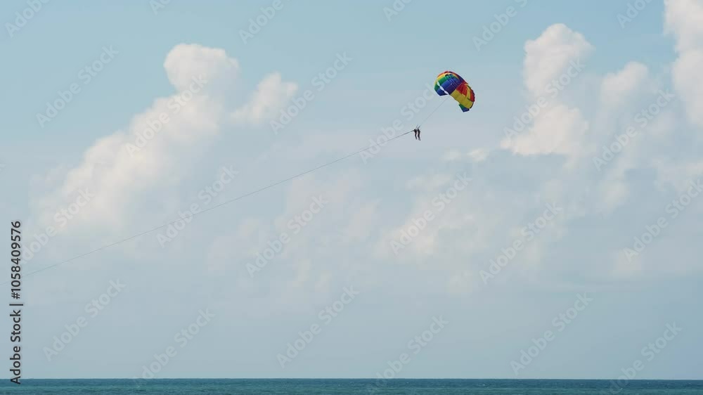 A parachutist glides through the sky above the ocean, capturing the thrill of adventure and sports. This scene embodies the excitement of outdoor activities, perfect for themes of leisure and fun. A parachutist glides through the sky above the ocean, capturing the thrill of adventure and sports. This scene embodies the excitement of outdoor activities, perfect for themes of leisure and fun.