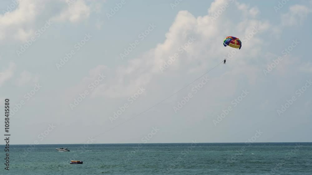 A parachutist glides through the sky above the ocean, capturing the thrill of adventure and sports. This scene embodies the excitement of outdoor activities, perfect for themes of leisure and fun. A parachutist glides through the sky above the ocean, capturing the thrill of adventure and sports. This scene embodies the excitement of outdoor activities, perfect for themes of leisure and fun.