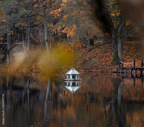 Beautiful small woodem houses for waterfowl in the lake. Overcast autumn landscape in Latvia. Seasonal scenery of Northern Europe. photo