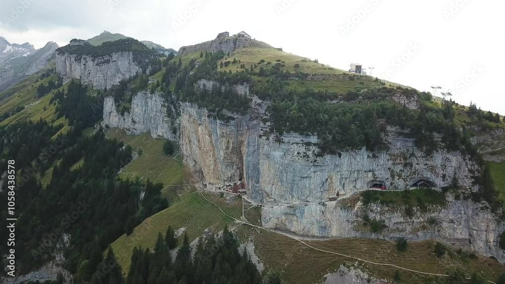 Wonderful aerial view of the Ebenalp mountain with the Wildkirchli caves and the Aescher cliff restaurant nestled into the rock face Alpstein, Switzerland Wonderful aerial view of the Ebenalp mountain with the Wildkirchli caves and the Aescher cliff restaurant nestled into the rock face Alpstein, Switzerland