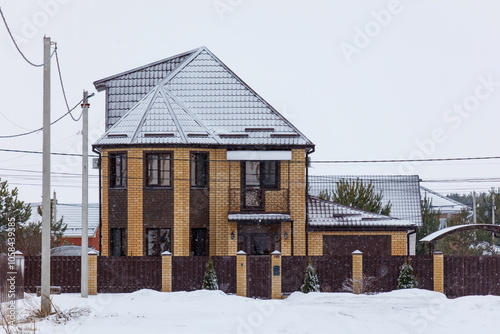 A large brown house with a snow covered roof