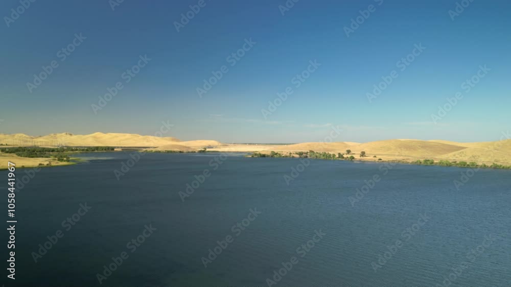 Aerial view highlighting the expansive beauty of San Luis Reservoir and its natural surroundings, ideal for fishing, boating, and outdoor exploration in Merced County, California. Aerial view highlighting the expansive beauty of San Luis Reservoir and its natural surroundings, ideal for fishing, boating, and outdoor exploration in Merced County, California.