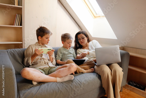 Two brothers and mother with smartphone and laptop photo