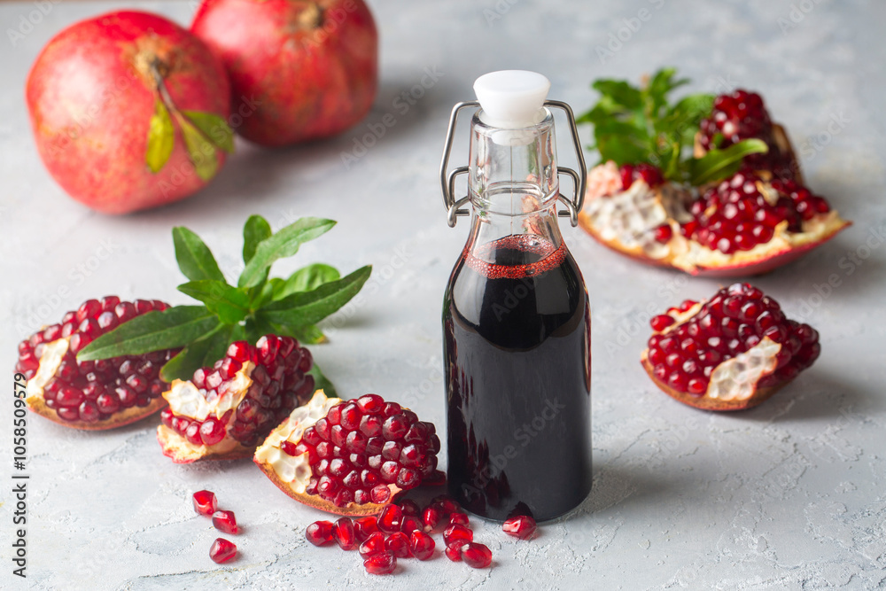 Organic homemade pomegranate syrup, pomegranate juice or pomegranate sauce with fresh pomegranate fruits. Turkish name; nar eksisi - nar suyu