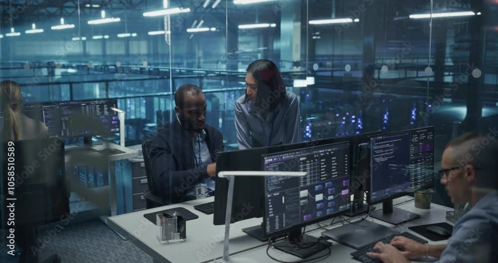 Modern Office in a Server Facility: Asian Female Data Scientist and Black Male Cybersecurity Expert Analyze Data Together on a Desktop Computer, Brainstorming New Security Solutions and Services