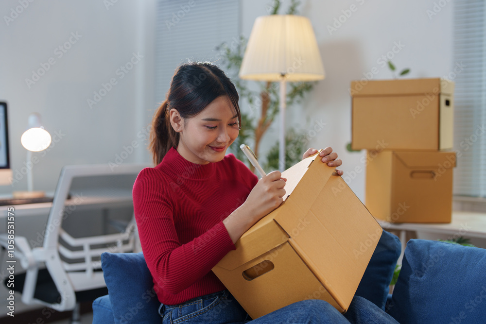 Startup girl, SME business owner, working with parcel boxes Recording names Address on the packaging box at the home office for delivery to the customer. Online sales ecommerce concept. Startup girl, SME business owner, working with parcel boxes Recording names Address on the packaging box at the home office for delivery to the customer. Online sales ecommerce concept.