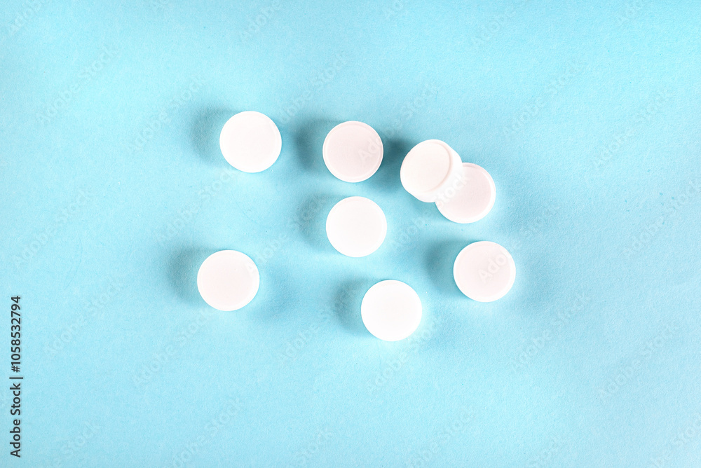 many different white pills on blue background. Assorted pharmaceutical medicine tablets, prescription drugs. many different white pills on blue background. Assorted pharmaceutical medicine tablets, prescription drugs.