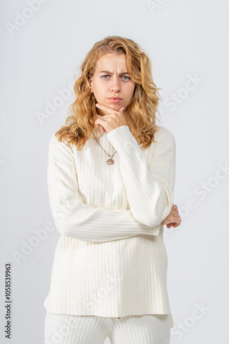 Half-length portrait of dissatisfied young attractive blonde girl on white background