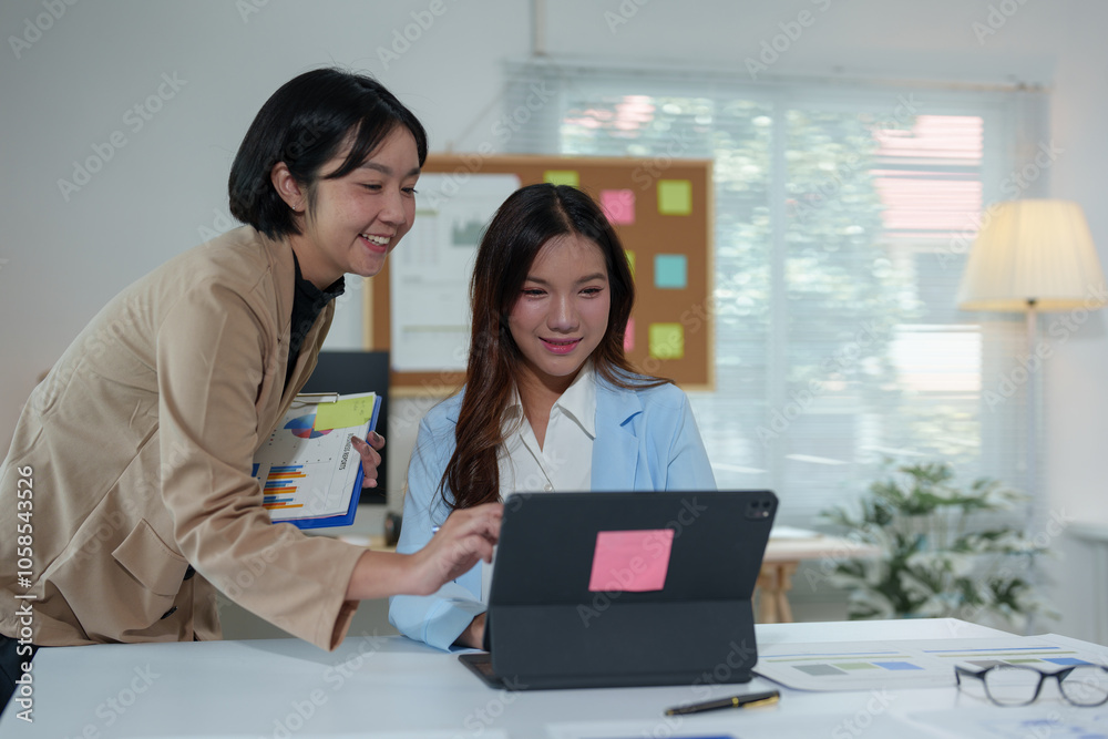 Two Asian businesswomen use laptops and smartphones in an open space office. Business concept. Data analysis, roadmap, marketing, accounting, auditing. Two Asian businesswomen use laptops and smartphones in an open space office. Business concept. Data analysis, roadmap, marketing, accounting, auditing.