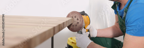 Obraz na płótnie Concentrated worker polishes board edge with grinding tool w salonie