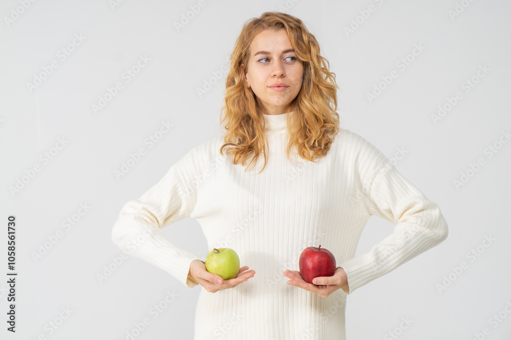 Happy attractive blonde young girl holding red and green apples, white background, copyspace. Concept of choice Happy attractive blonde young girl holding red and green apples, white background, copyspace. Concept of choice