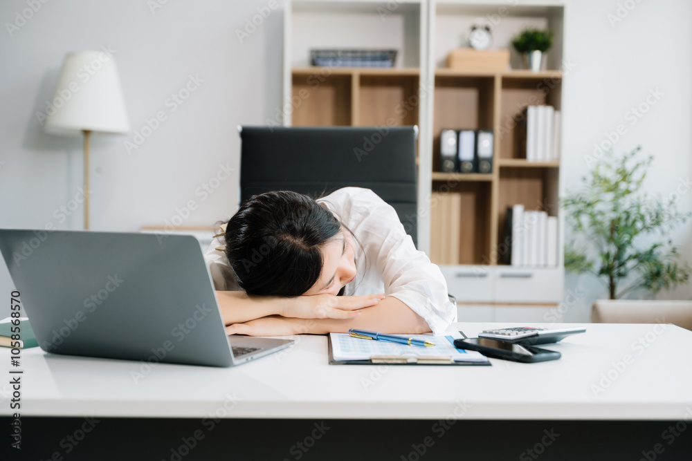 Asian business woman is stressed, bored, and overthinking from working on a tablet Asian business woman is stressed, bored, and overthinking from working on a tablet