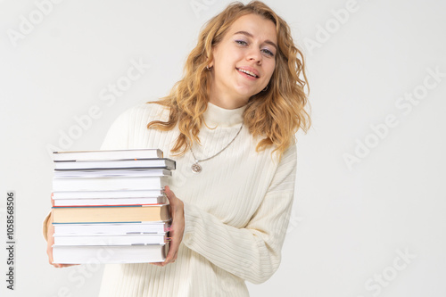 Cute young blonde girl with books in her hands, white background, copyspace