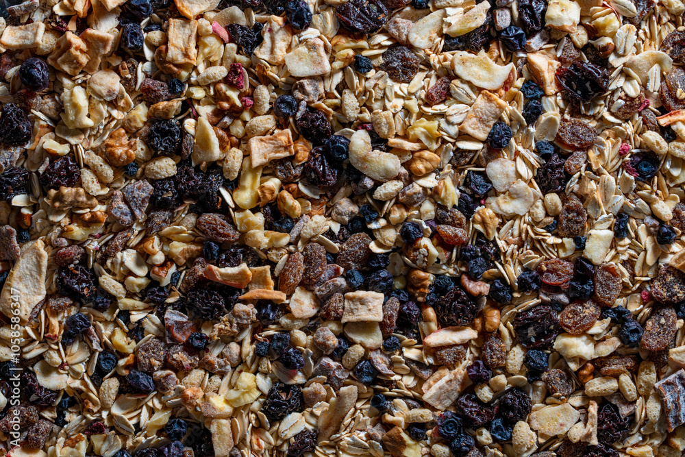 Whole grain oat muesli with dried fruits, nuts, raisins and berries, top view, closeup. Background of organic muesli for breakfast Whole grain oat muesli with dried fruits, nuts, raisins and berries, top view, closeup. Background of organic muesli for breakfast
