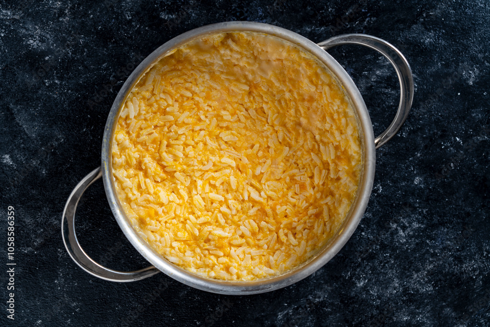 Φωτογραφία Sweet pumpkin porridge with white rice, honey and milk in a saucepan on a table, closeup, top view