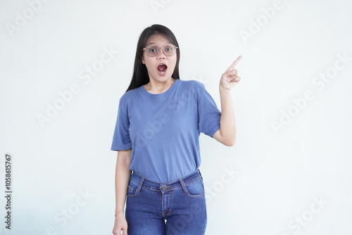 beautiful Asian woman makes a pointing gesture with her fingers, set against a clean white background