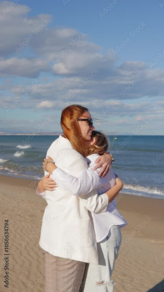 Mother and daughter sharing tender hug on beach Mother and daughter sharing tender hug on beach