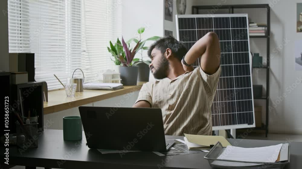 Young Indian engineer getting tired while working on laptop for hours at workplace in office Young Indian engineer getting tired while working on laptop for hours at workplace in office