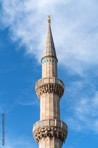 The minaret of the mosque against the background of a blue sky with clouds, the architecture of the Islamic religion photo