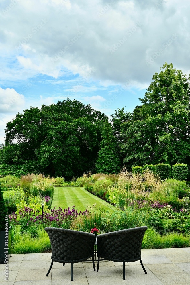 Sunny garden in England. with variety of flowers and green plants in a lush and garden composition Sunny garden in England. with variety of flowers and green plants in a lush and garden composition