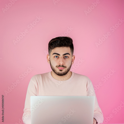 Man  working with laptop on pinkbackground
 photo