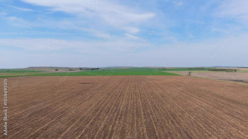 Aerial shot of a brown field, flying above, green fields in the horizon, agriculture on a sunny day, slow motion, copy space Aerial shot of a brown field, flying above, green fields in the horizon, agriculture on a sunny day, slow motion, copy space